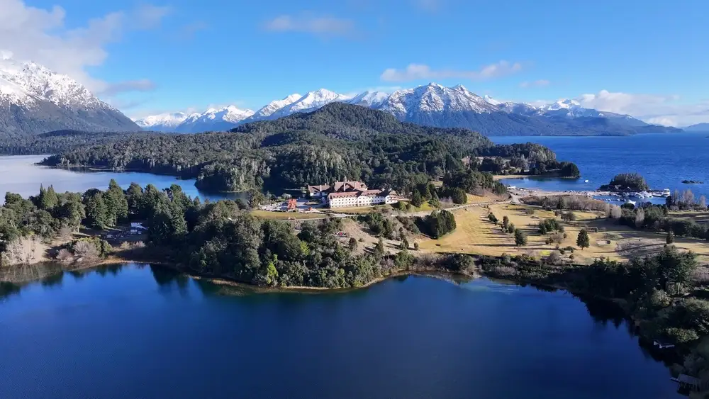 Nahuel Huapi lake with a wooded peninsula, and snow peaks behind