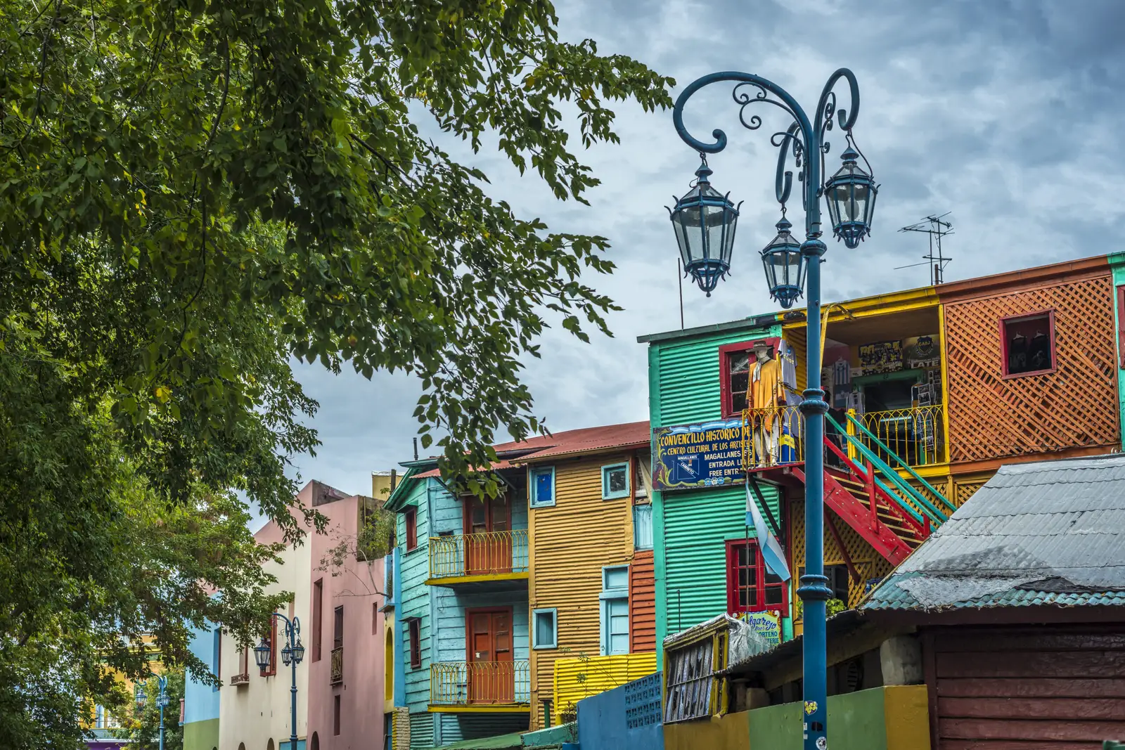 A street lamp on Caminito, with the painted houses behind it