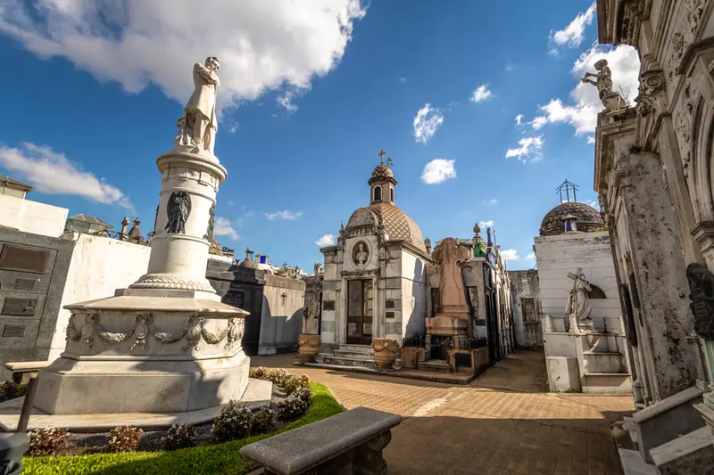 A statue on a monument among the mausoleums