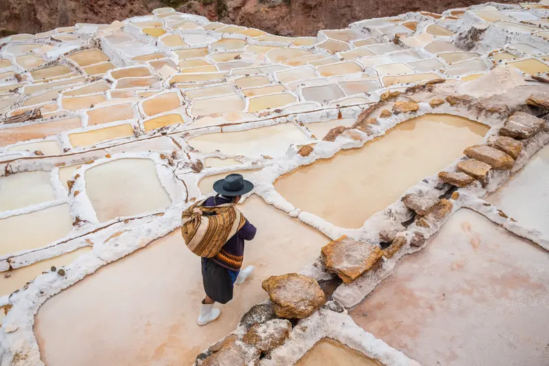 Maras Salt mine ponds with a woker