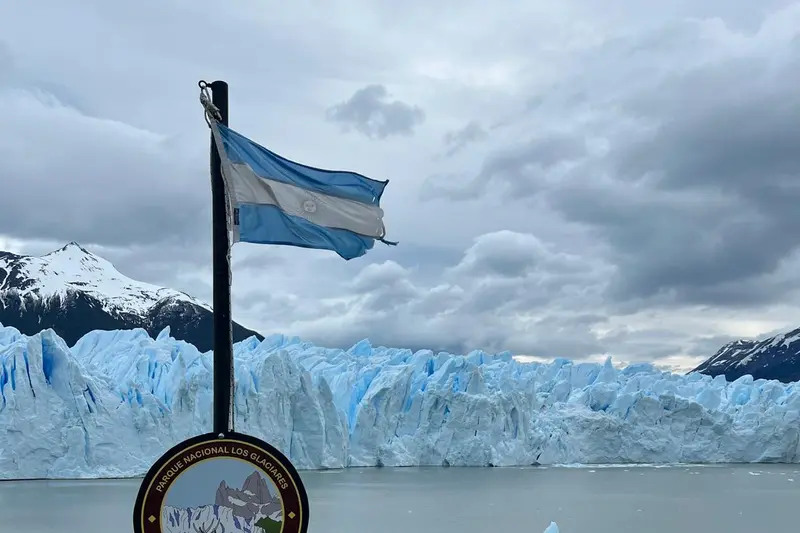 An Argentine flag in front of the front wall of the Perito Moreno glacier