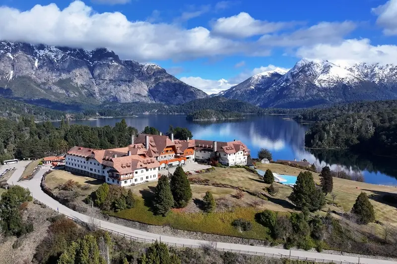 A lakeside hotel from the air, with the mountains behind it
