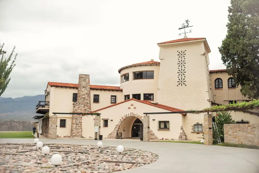 A winery building with a tower, with the hills behind it