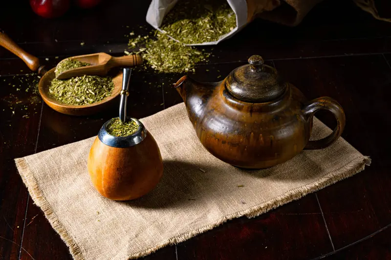 A mate gourd and a kettle on a cloth
