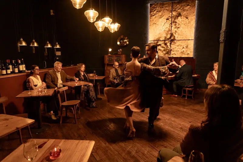 Dancers on the floor of a dimly lit tango venue