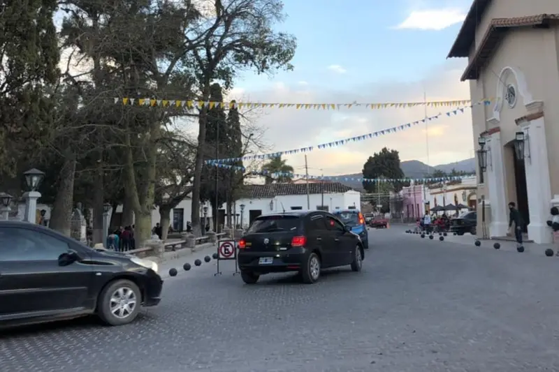A street in Cachi with bunting overhead and a white church