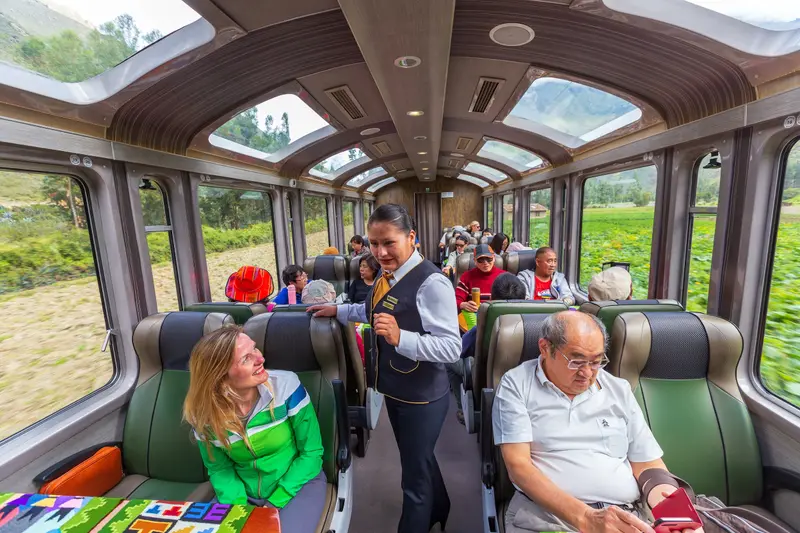 Passengers and staff inside a panoramic train carriage