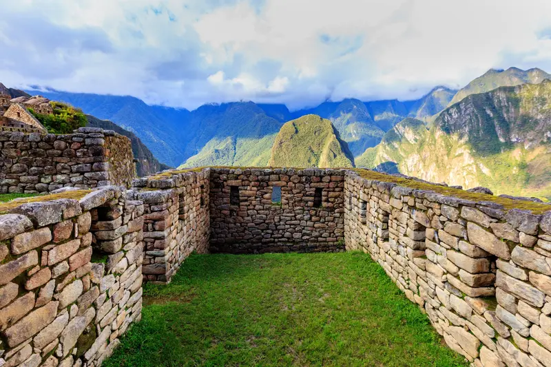 A stone enclosure at the site, with the peaks behind it