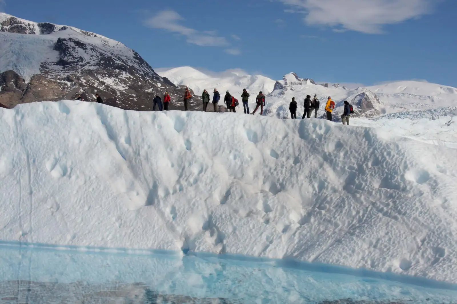 A line of walkers roped together on the glacier