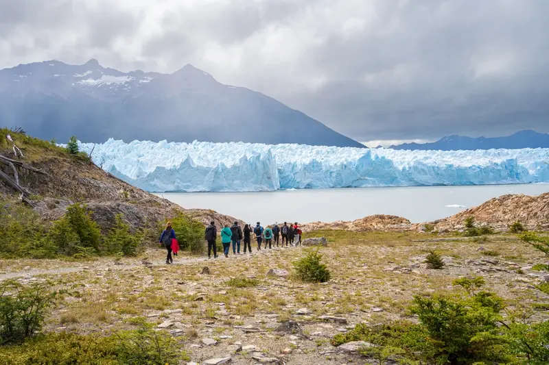 The glacier front seen across the moraine, with a group of visitors
