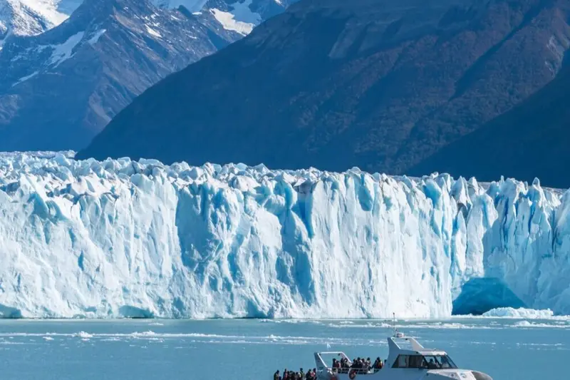 The glacier wall, with ice broken off in the water below