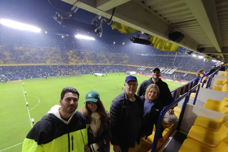 A group in the stands with the pitch behind them
