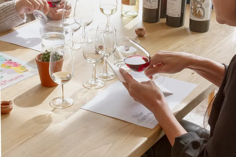 A tasting table with glasses lined up and notes beside them