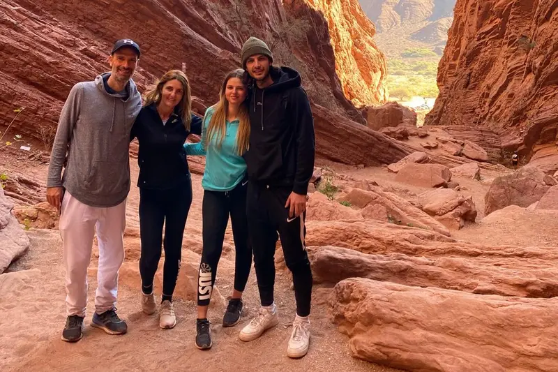 Four people standing in a canyon of red rock