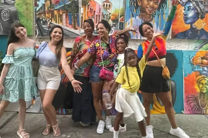 A group of women in a street covered in murals