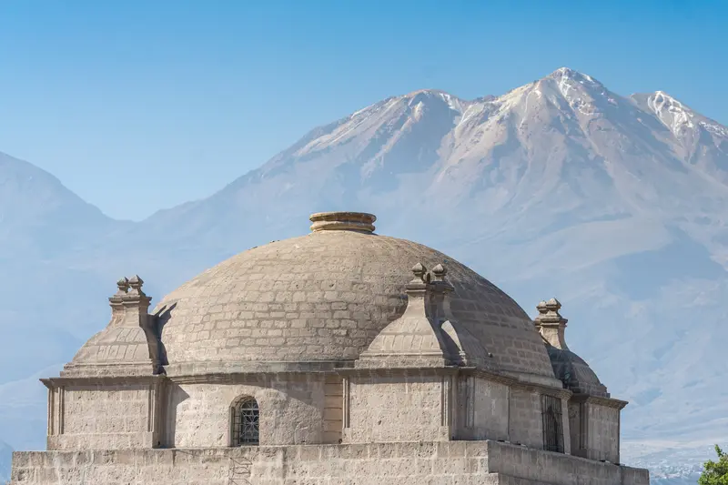 A domed stone building with the volcano behind it