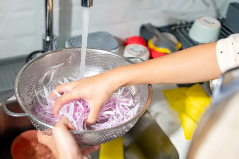Chef rinsing onions for ceviche preparation