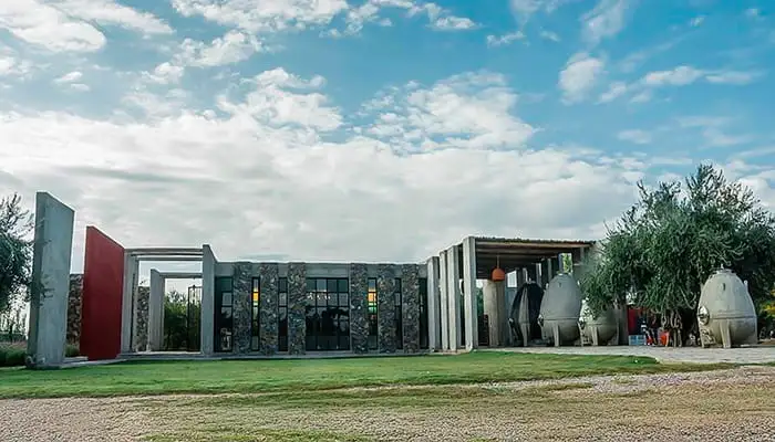 A winery of concrete and stone, with the lawn in front of it