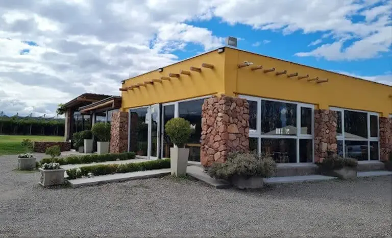 A yellow winery building with a stone base