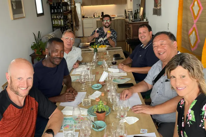 A group seated along a long table in the kitchen