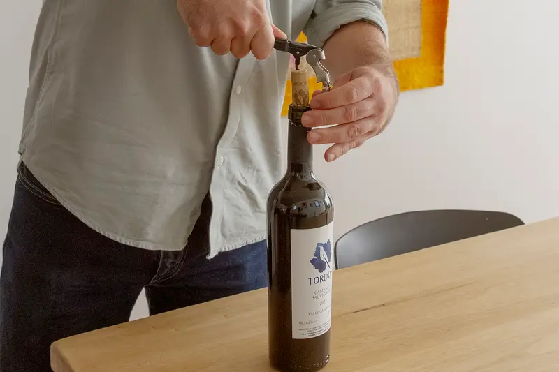 Hands opening a bottle of wine