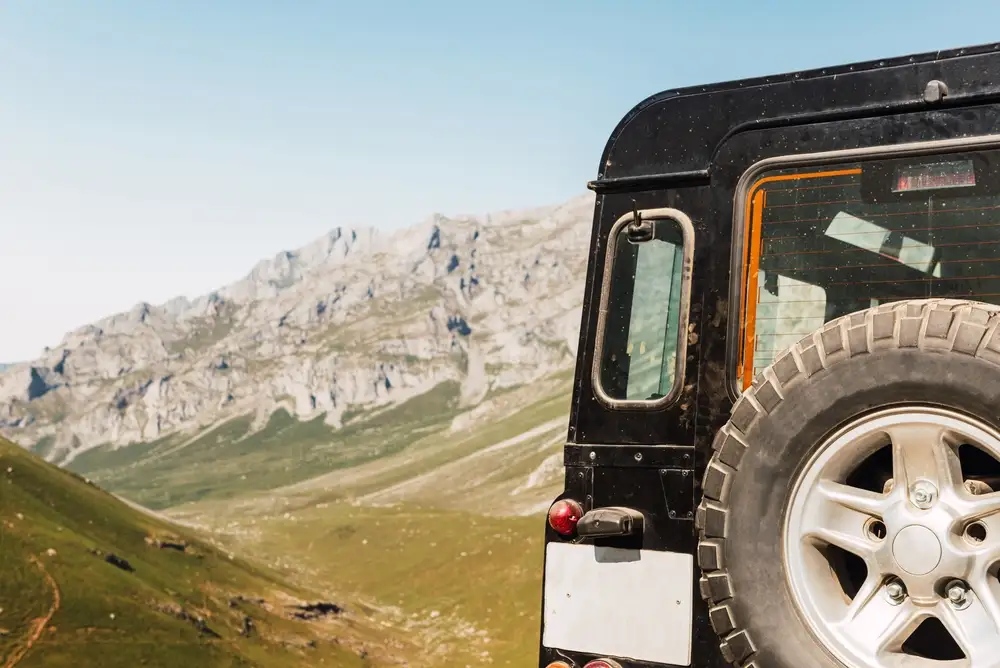 A four-wheel drive parked on a dirt track in the hills