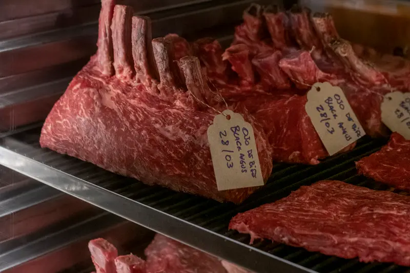 Labelled cuts of beef on a rack in the ageing room
