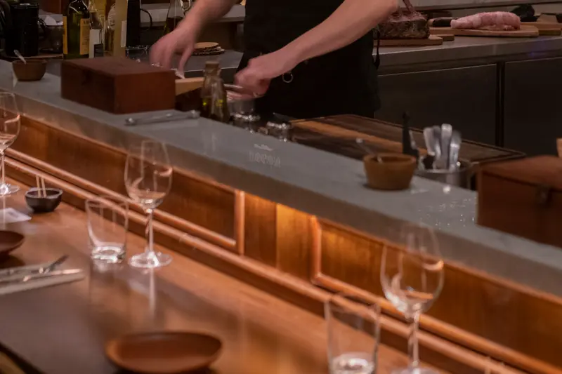 Hands working behind the counter, glasses set out in front