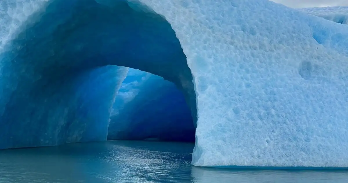 An iceberg with an arch of blue ice