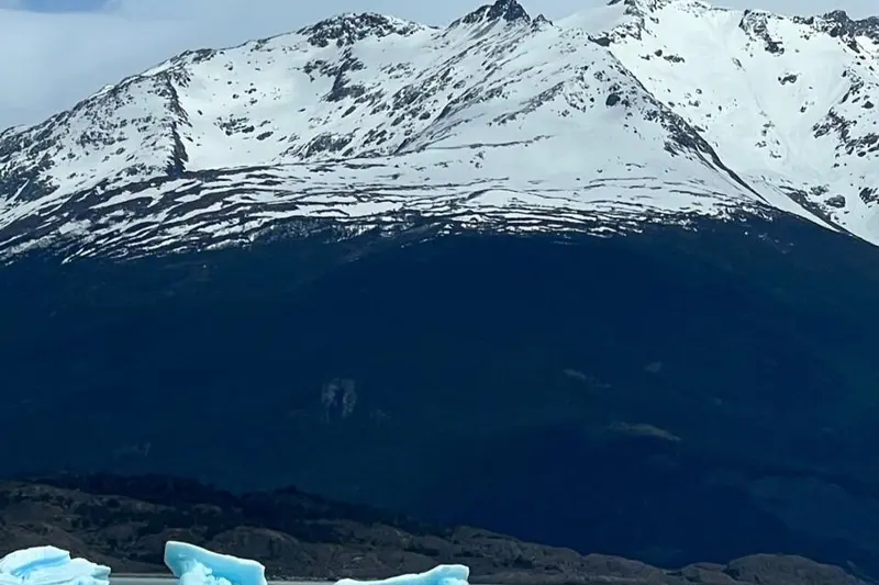 A snow-covered peak above dark water