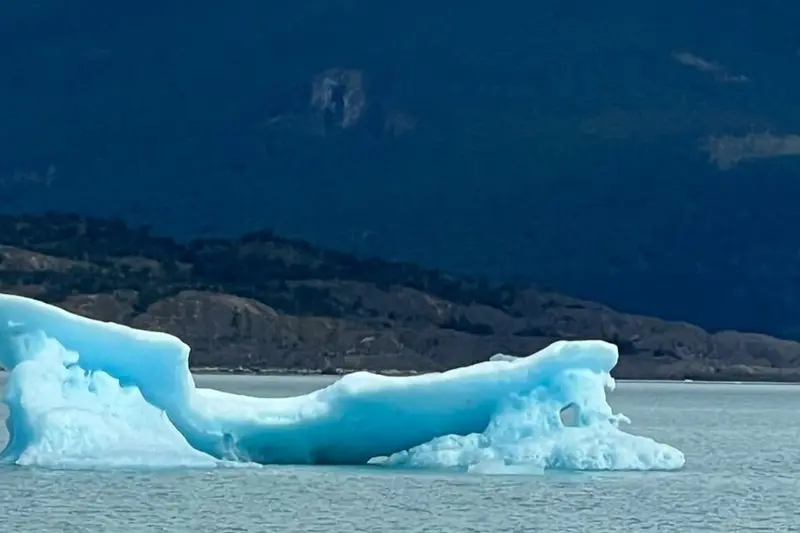 An iceberg on the lake, blue at the waterline