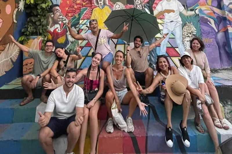 A group sitting on painted steps in Getsemaní