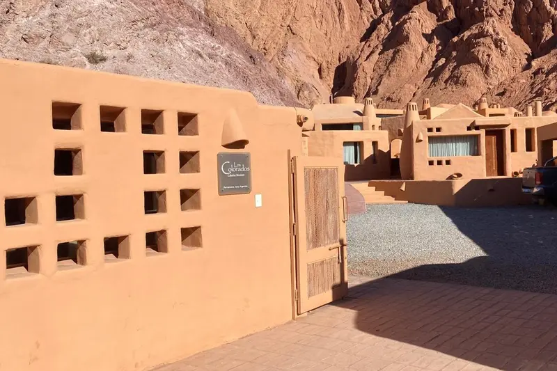 An adobe building with lattice windows, in the dry hills
