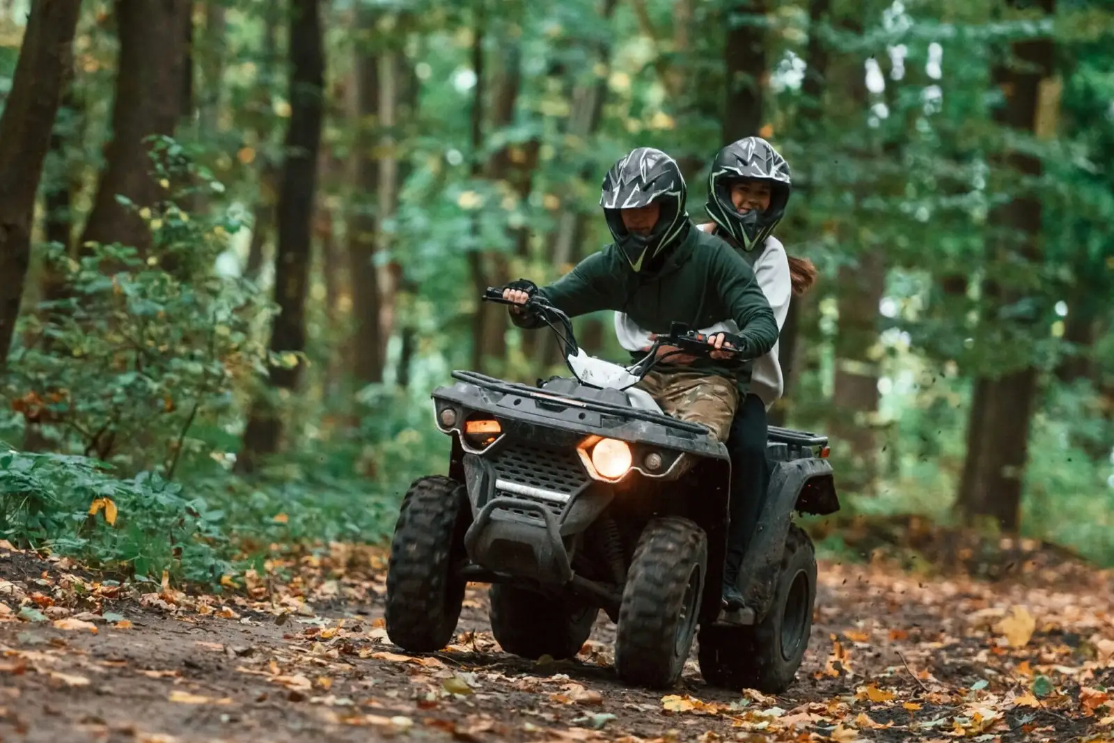 Two riders on a quad bike in the woods