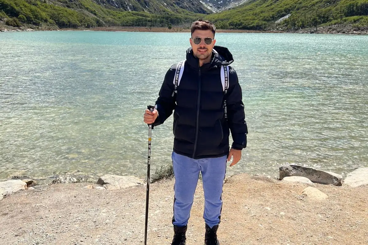 A walker with poles beside the green lake