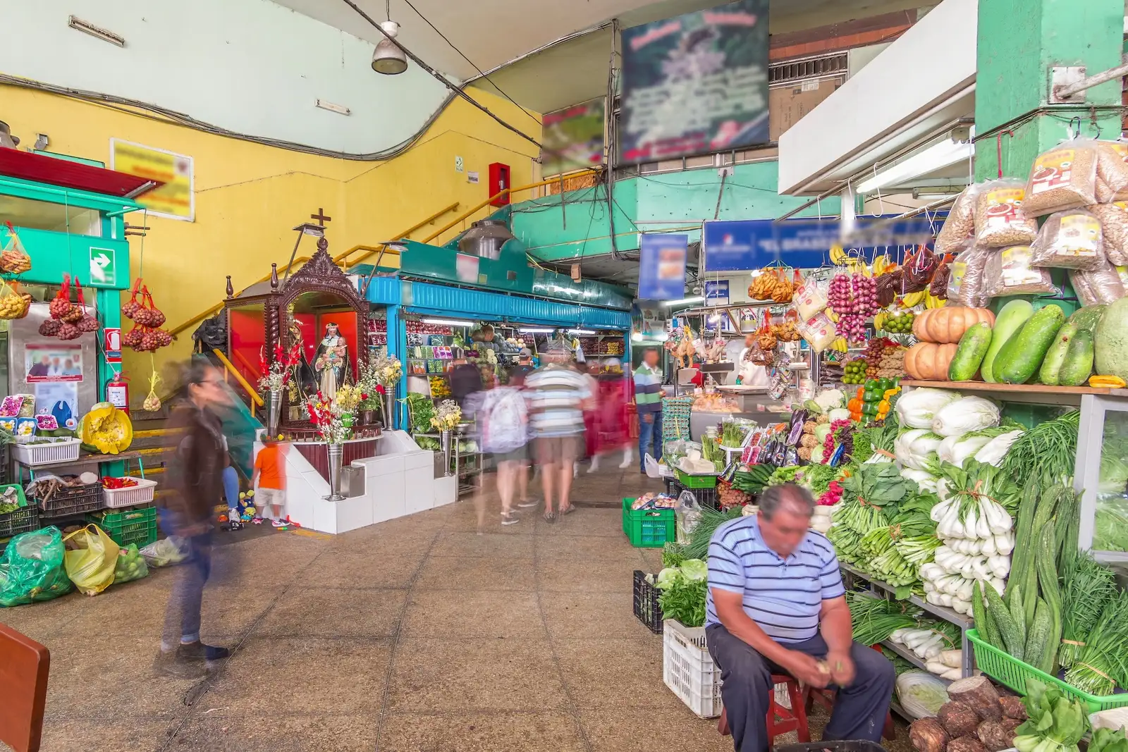 A market aisle with fruit and vegetable stalls