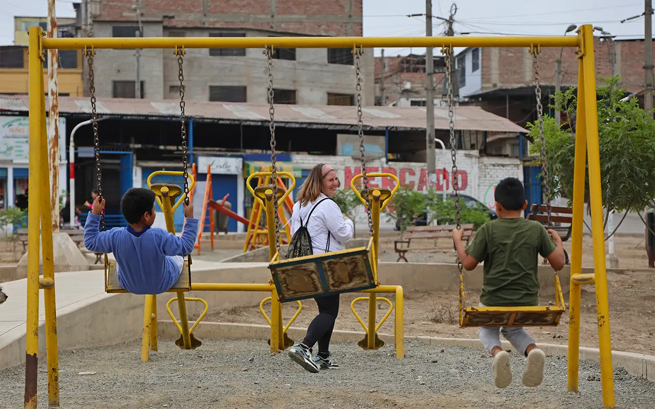 Children on the swings at a hillside playground