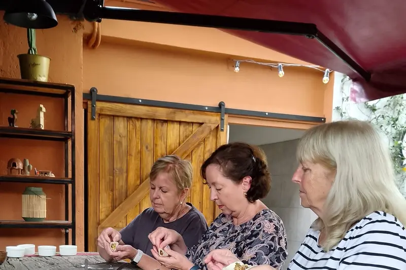 Three people folding empanadas together