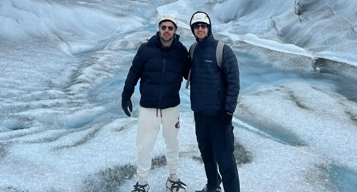 Two walkers standing on the ice of the glacier