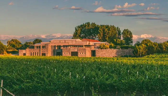 A stone lodge behind a field of yellow flowers