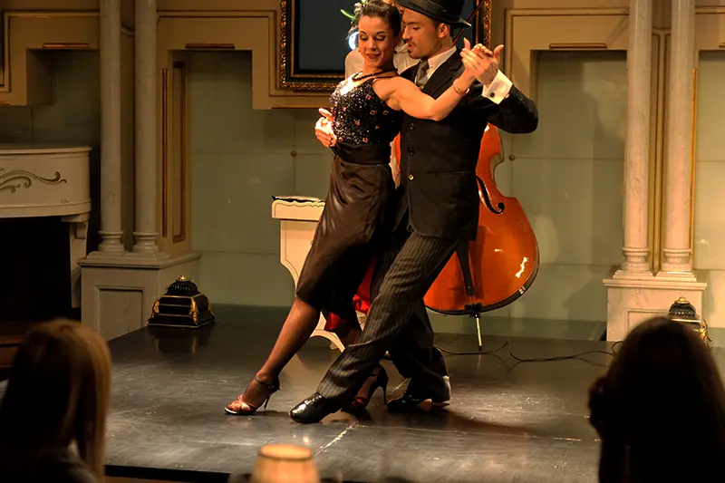 A tango couple dancing, with a double bass behind them