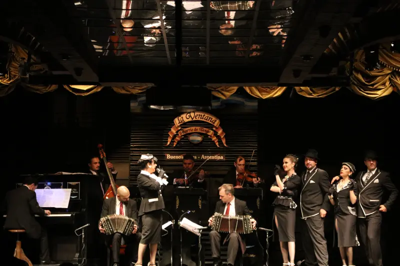 The orchestra and the dancers together on a lit stage