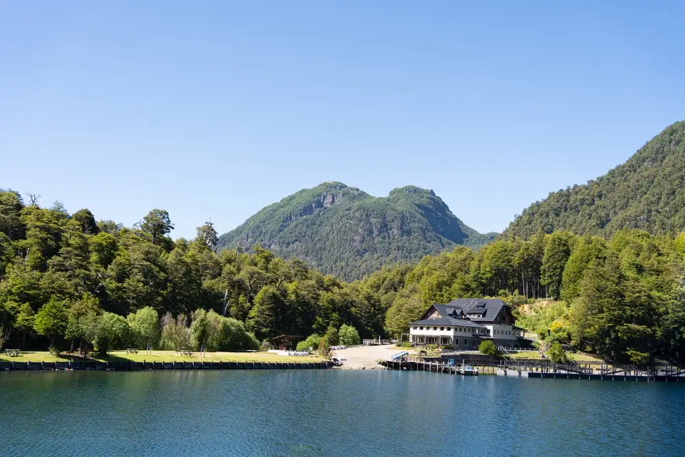 A jetty and a lodge on the lake, with wooded hills behind