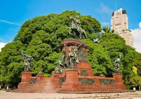 An equestrian monument under a large tree