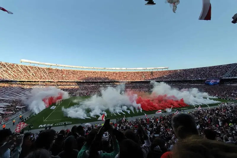 The stands with red and white flares lit along them