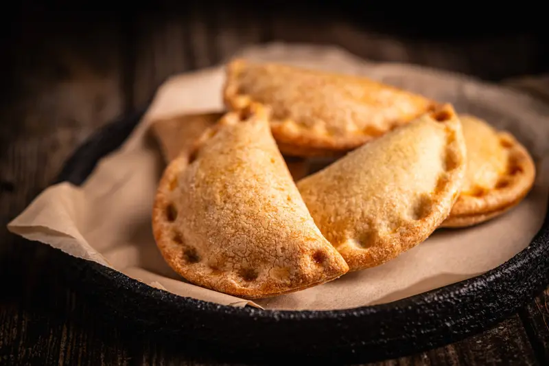 Two empanadas in a lined basket