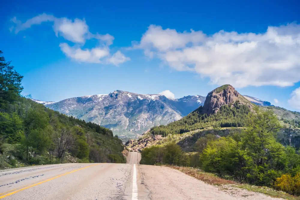 An empty road running towards the mountains
