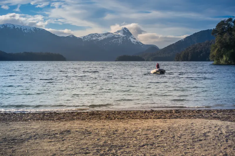 A lake shore with mountains at the far end
