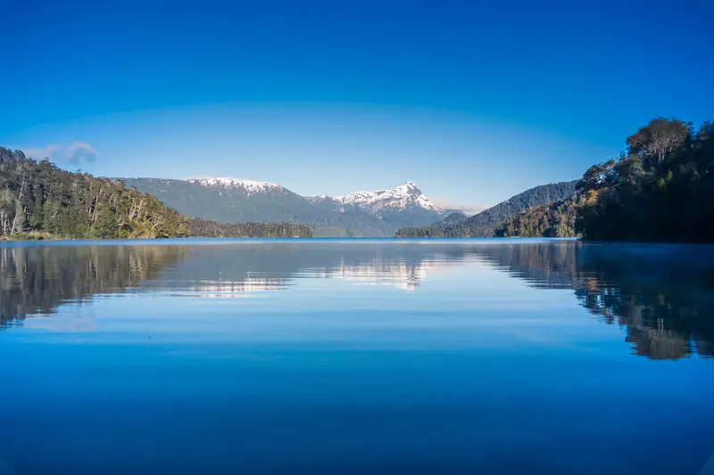 A still lake with snow peaks at the far end