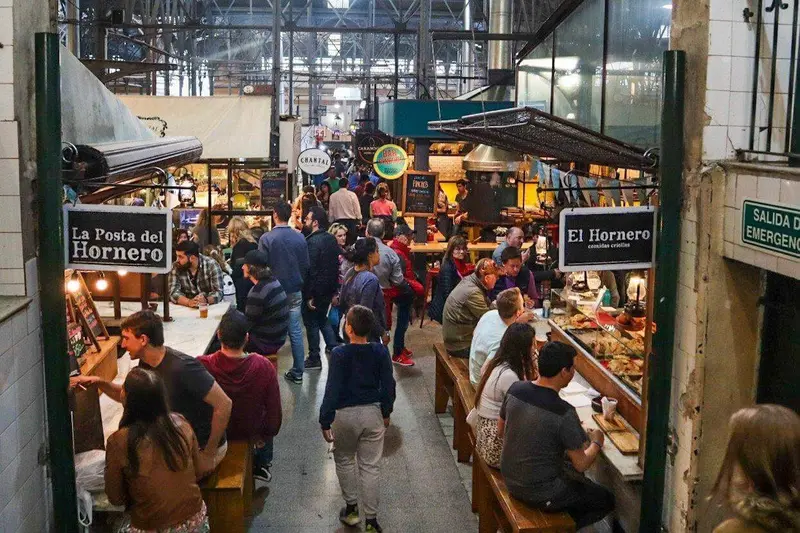 Inside the San Telmo market, stalls and people at the counters